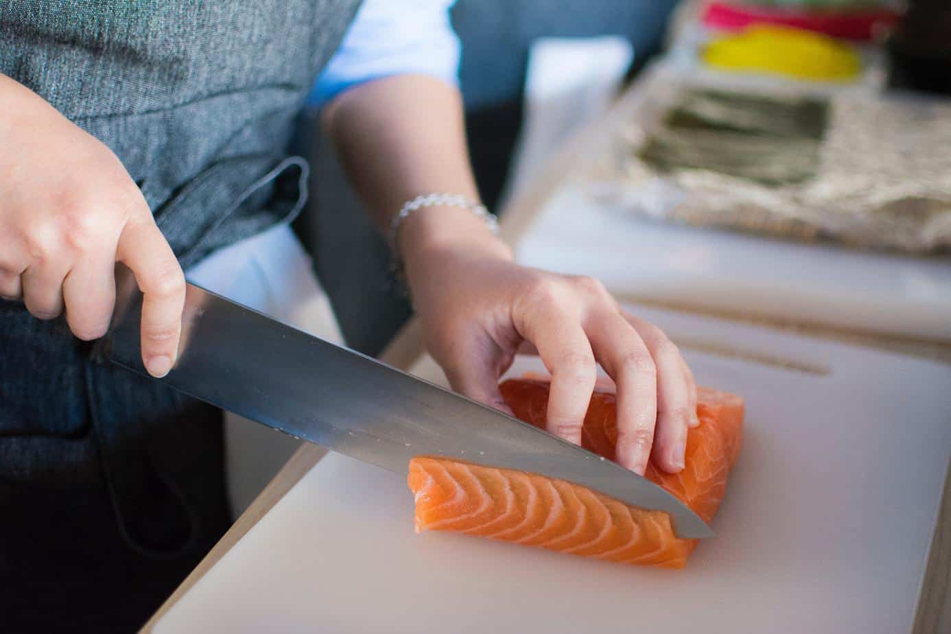 mercer genesis knives being used to slice fresh salmon.