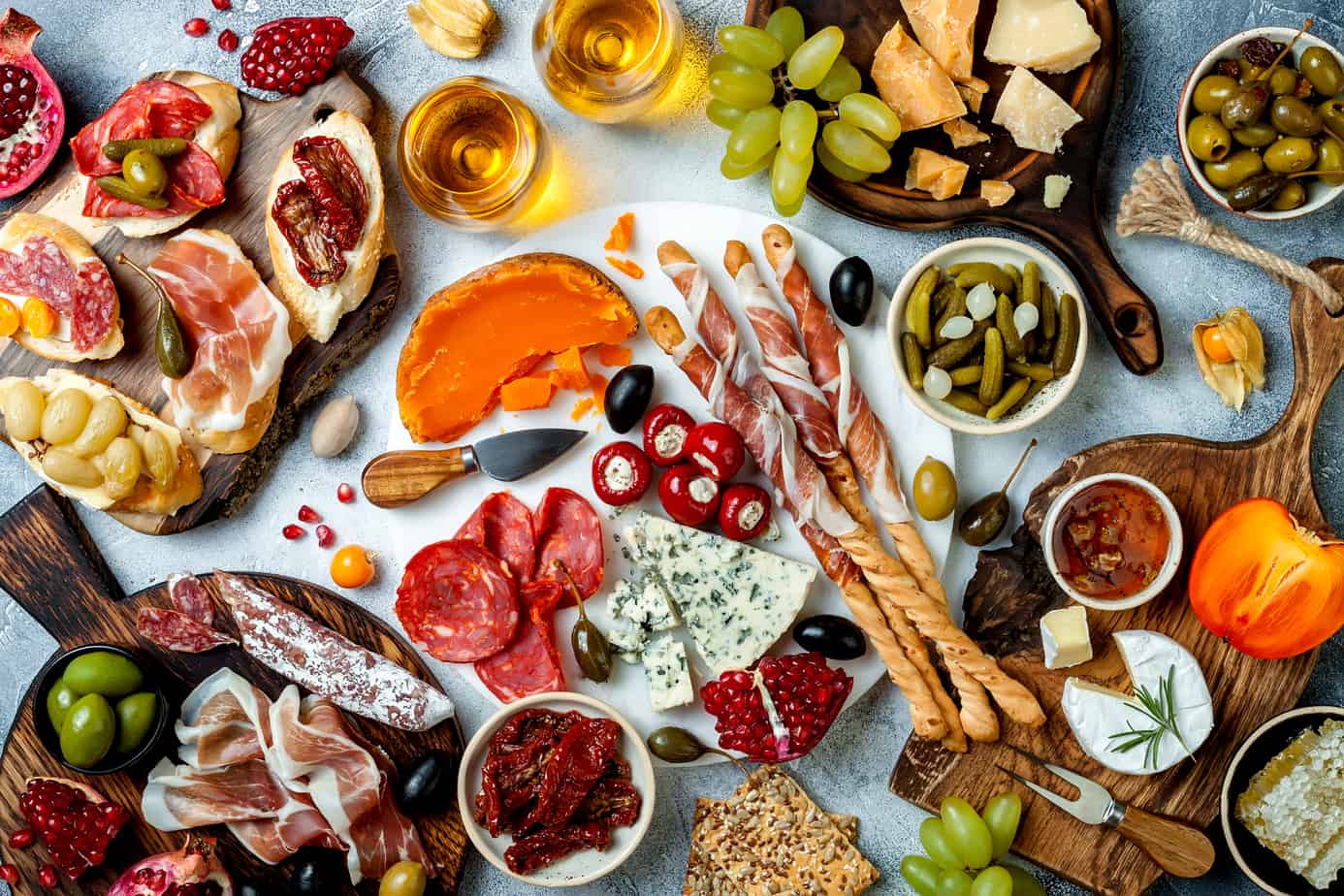 assorted charcuterie, pickled vegetables, and cheeses on a grazing tables
