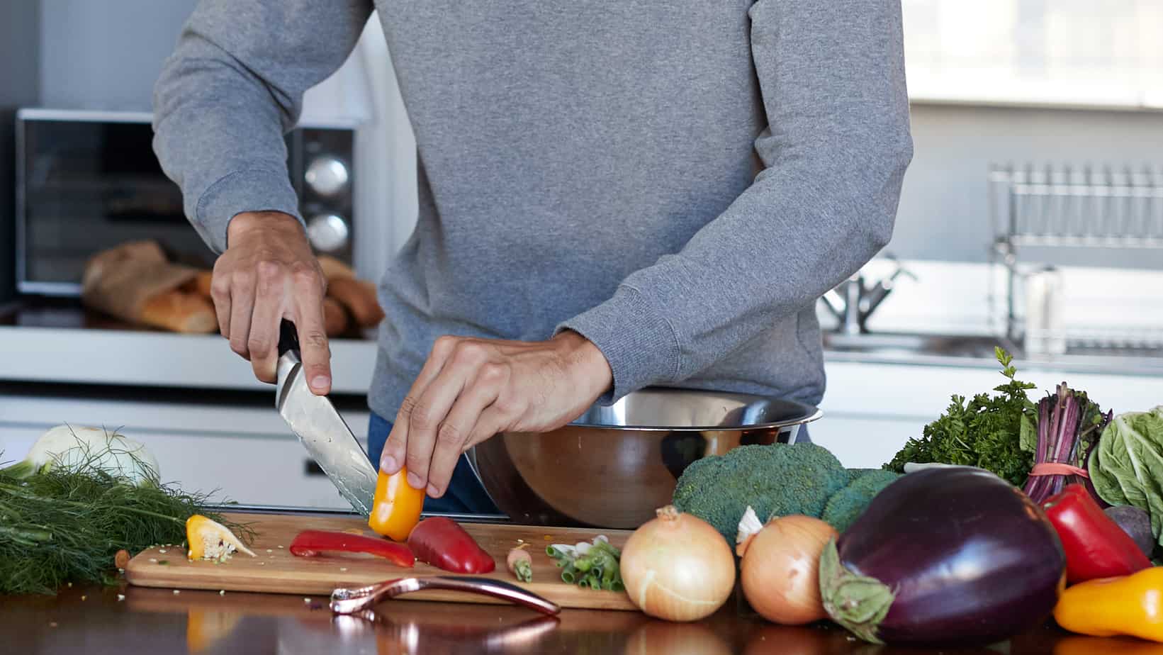 using a chefs knife to cut vegetables.