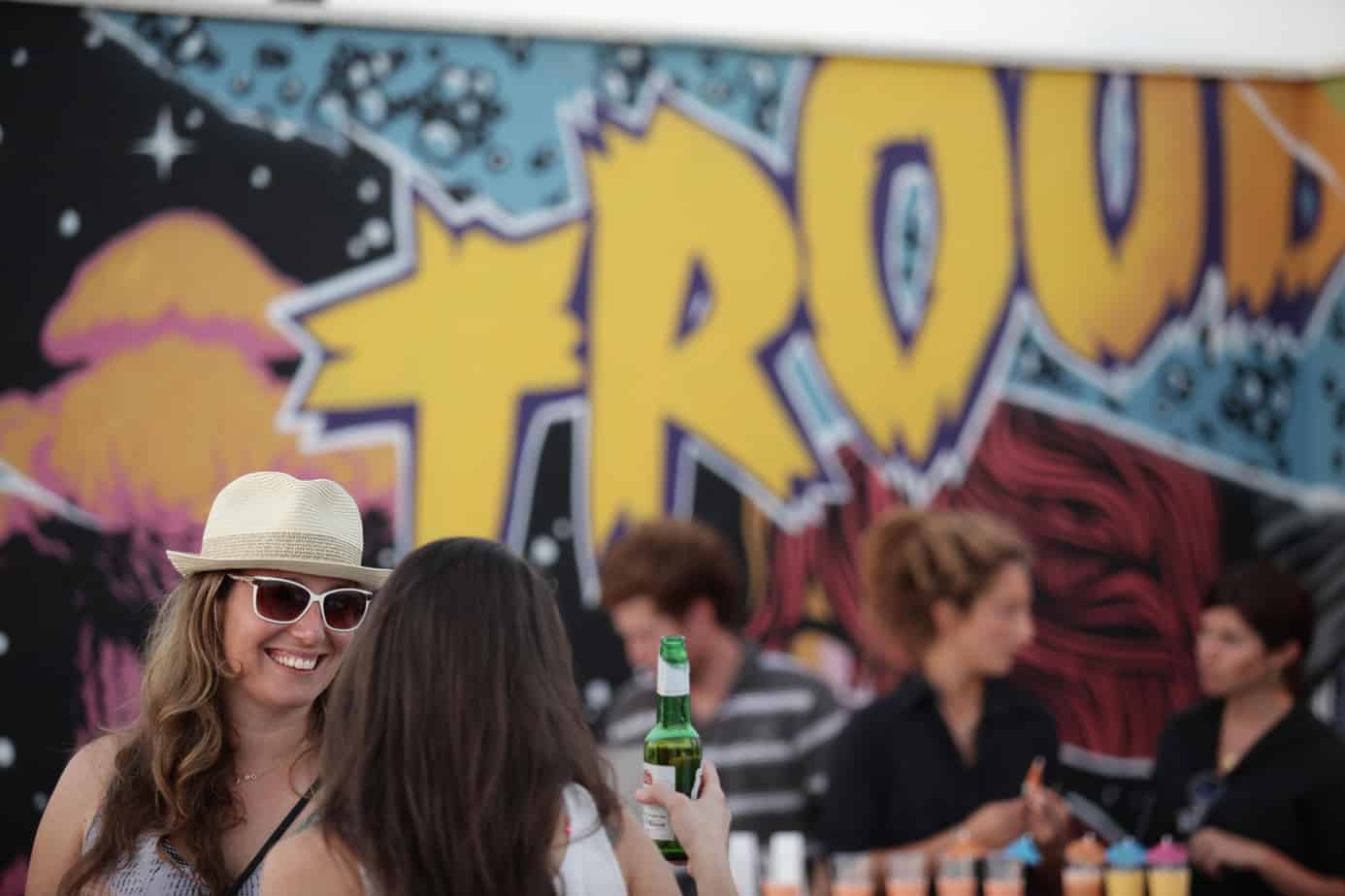 women outdoors enjoying eachothers company during girls night out, one is holding a beer.