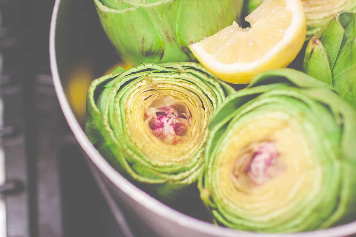 artichokes in a pot with a lemon