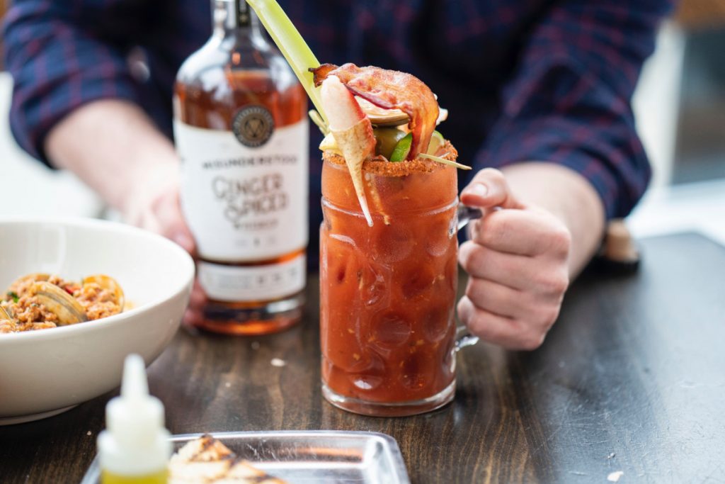 Bloody mary cocktail served with bacon, green olives, and a dungeness crab claw. 