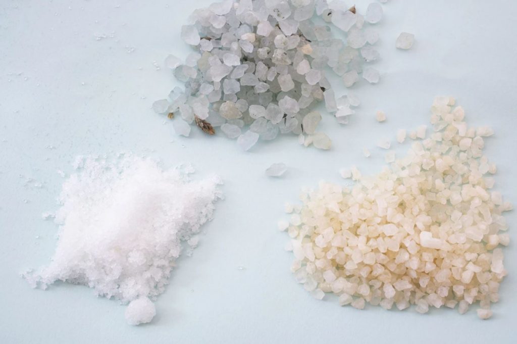 secret ingredients of three piles of coarse salts of different shades of color