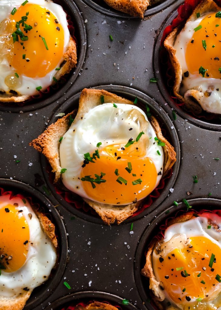 Ramekin containing crab, bacon, and bread pudding melange, topped with hollandaise sauce and a poached egg. 