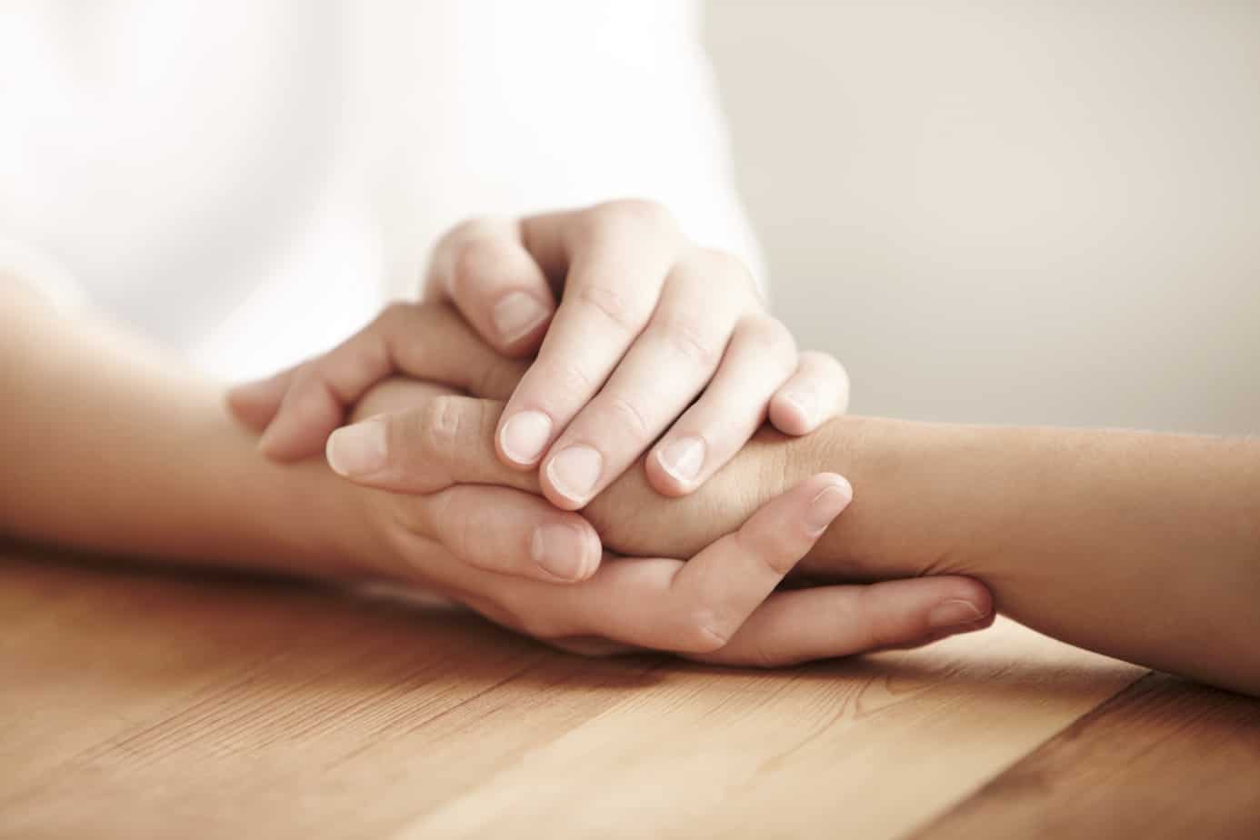 two people holding hands for comfort.