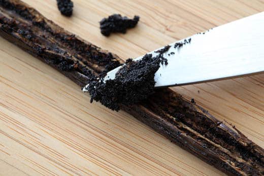 scraping out a vanilla bean with a knife