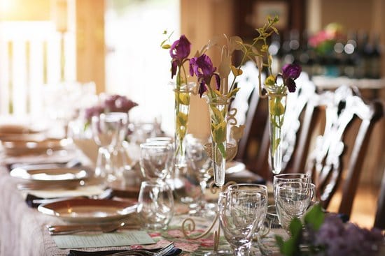 a fancy dinner table set beautifully with china, silverware and glassware, ready for a dinner party with a private chef.