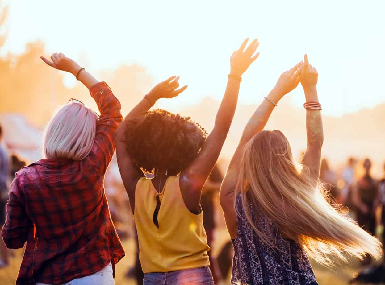 3 ladies enjoying music and dancing outdoors during their girls night in party.