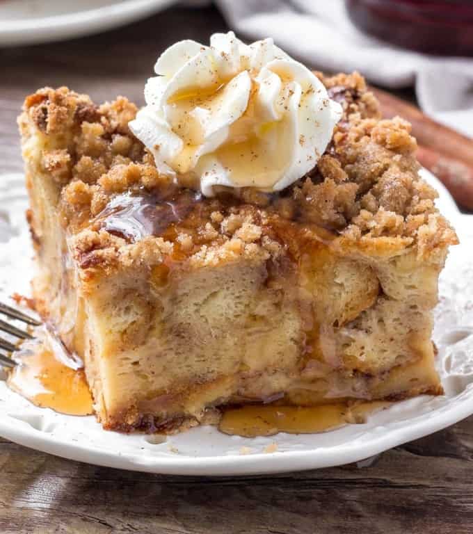 make ahead breakfast bread pudding also known as baked french toast, topped with whipped cream and cinnamon