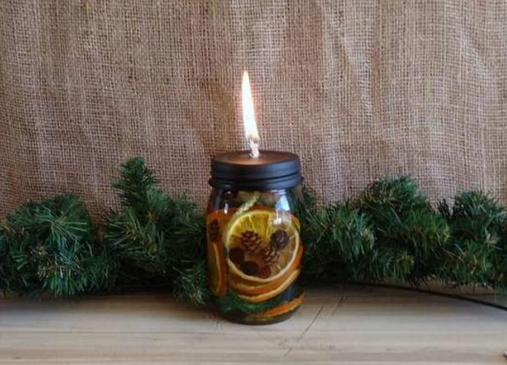 mason jar containing holiday scented fruits and pinecones