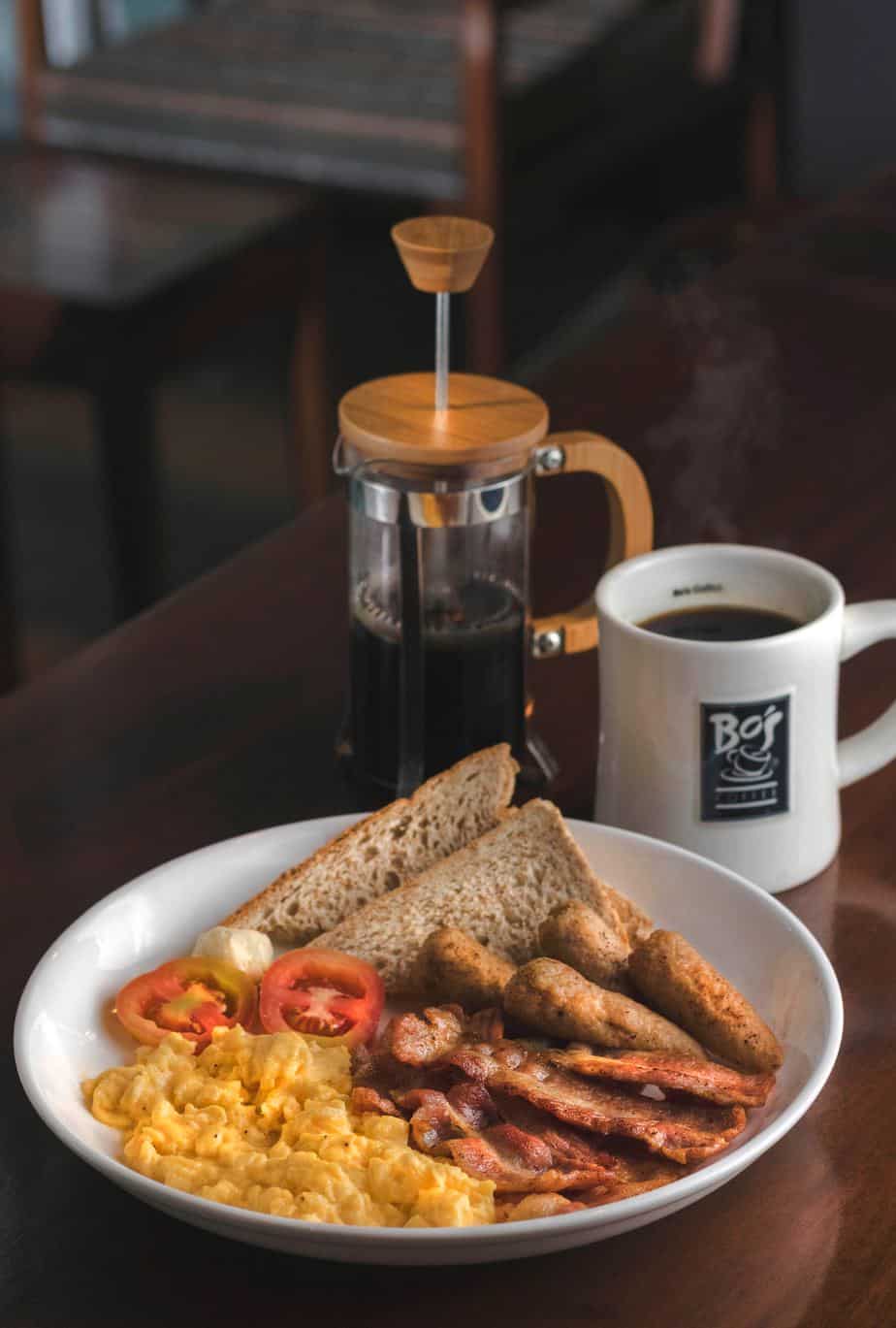 make ahead breakfast with toast, bacon, sausage, eggs, and tomatoes with coffee.