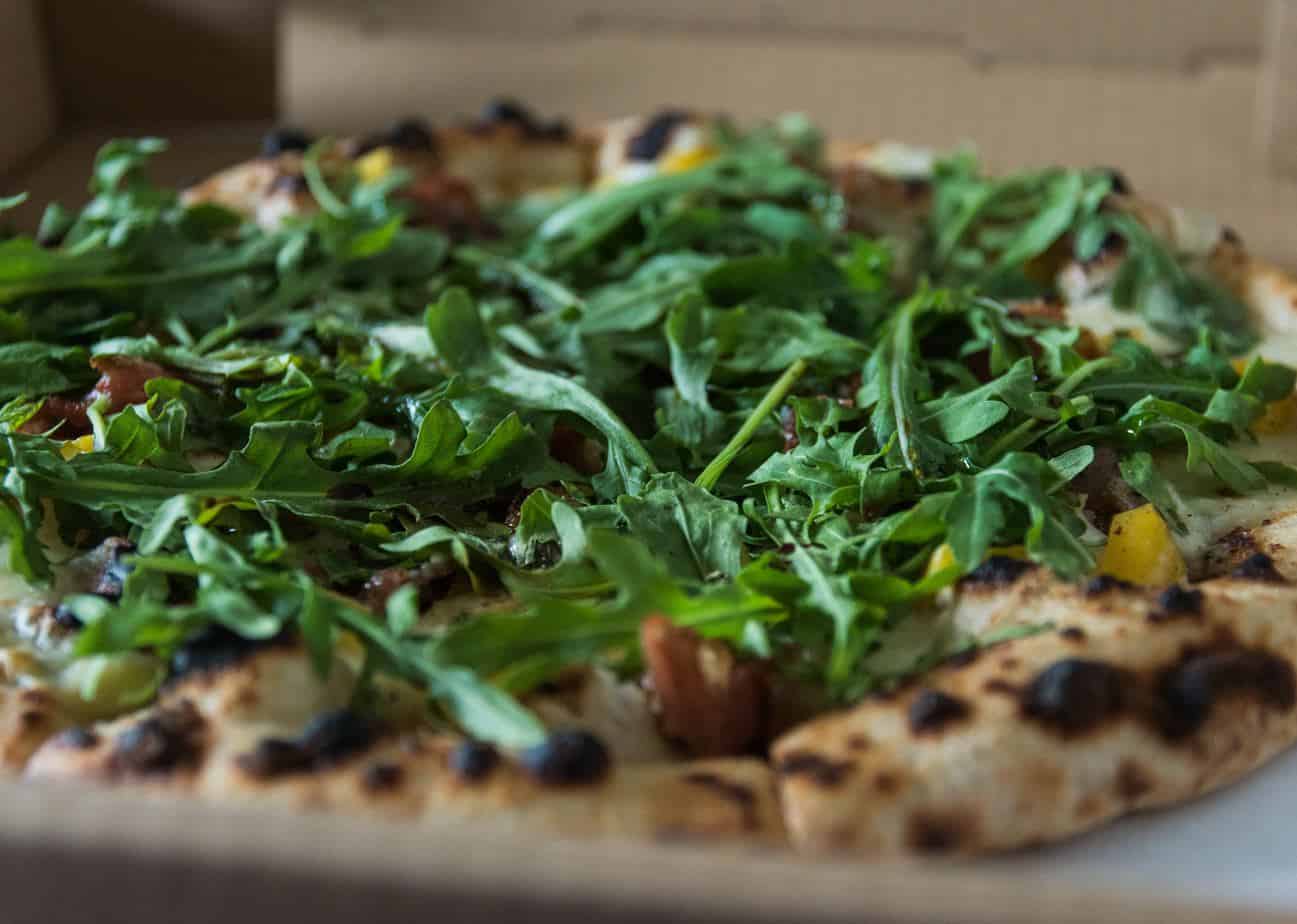 fresh arugula on top of a pizza