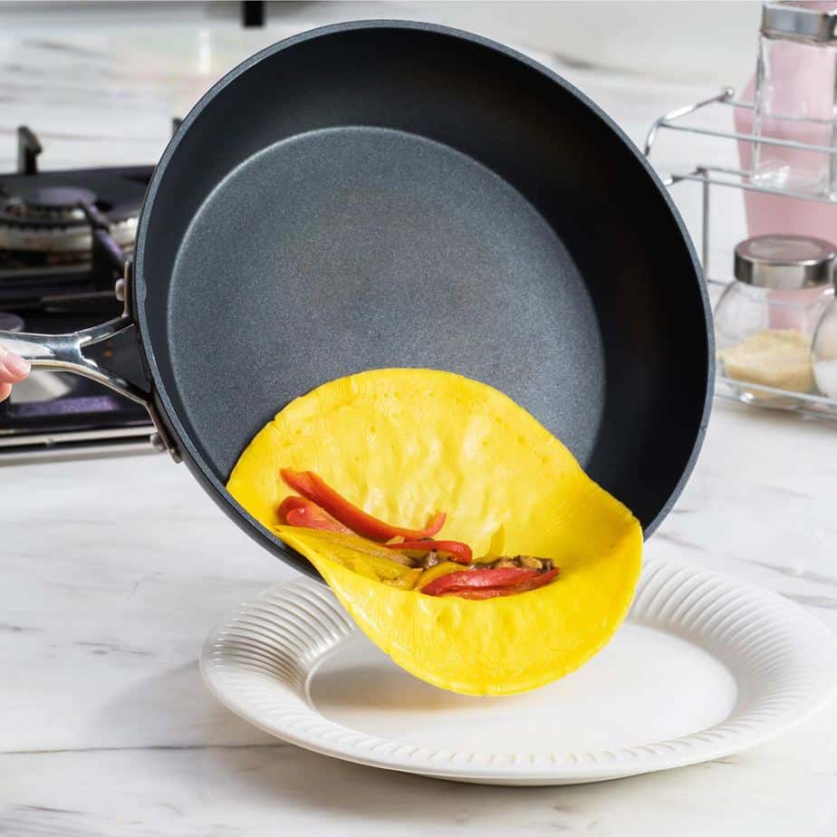 omelette in a pan being turned out onto a plate.